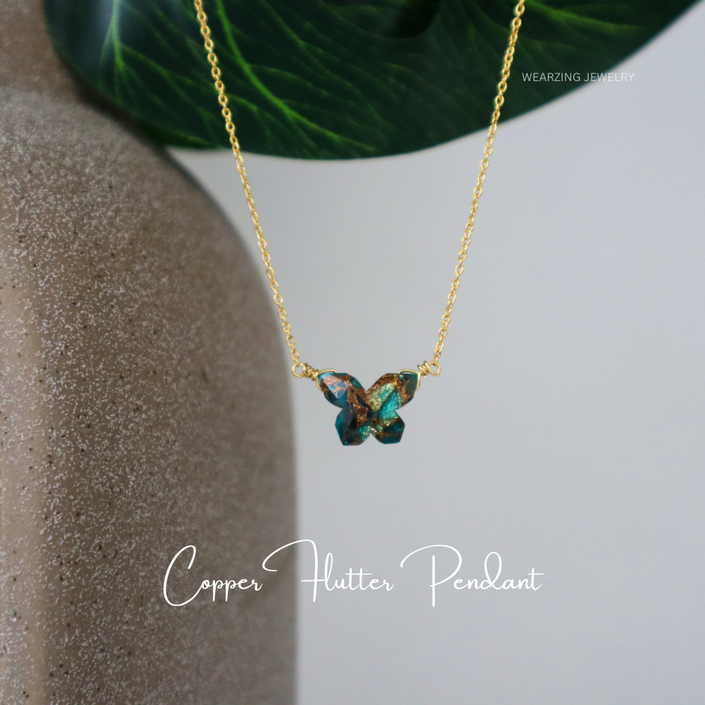 Gold necklace with a butterfly pendant on a neutral background