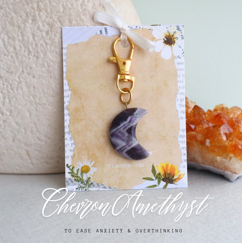 Keychain with crescent moon charm on a decorative card with crystals in the background