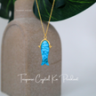 Turquoise crystal koi pendant necklace on a neutral background