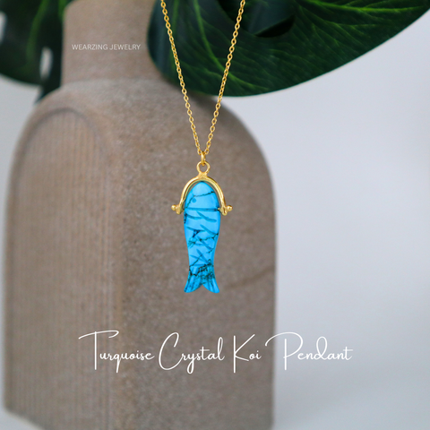 Turquoise crystal koi pendant necklace on a neutral background