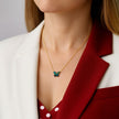 Necklace with a butterfly pendant worn by a person in a red and white outfit.
